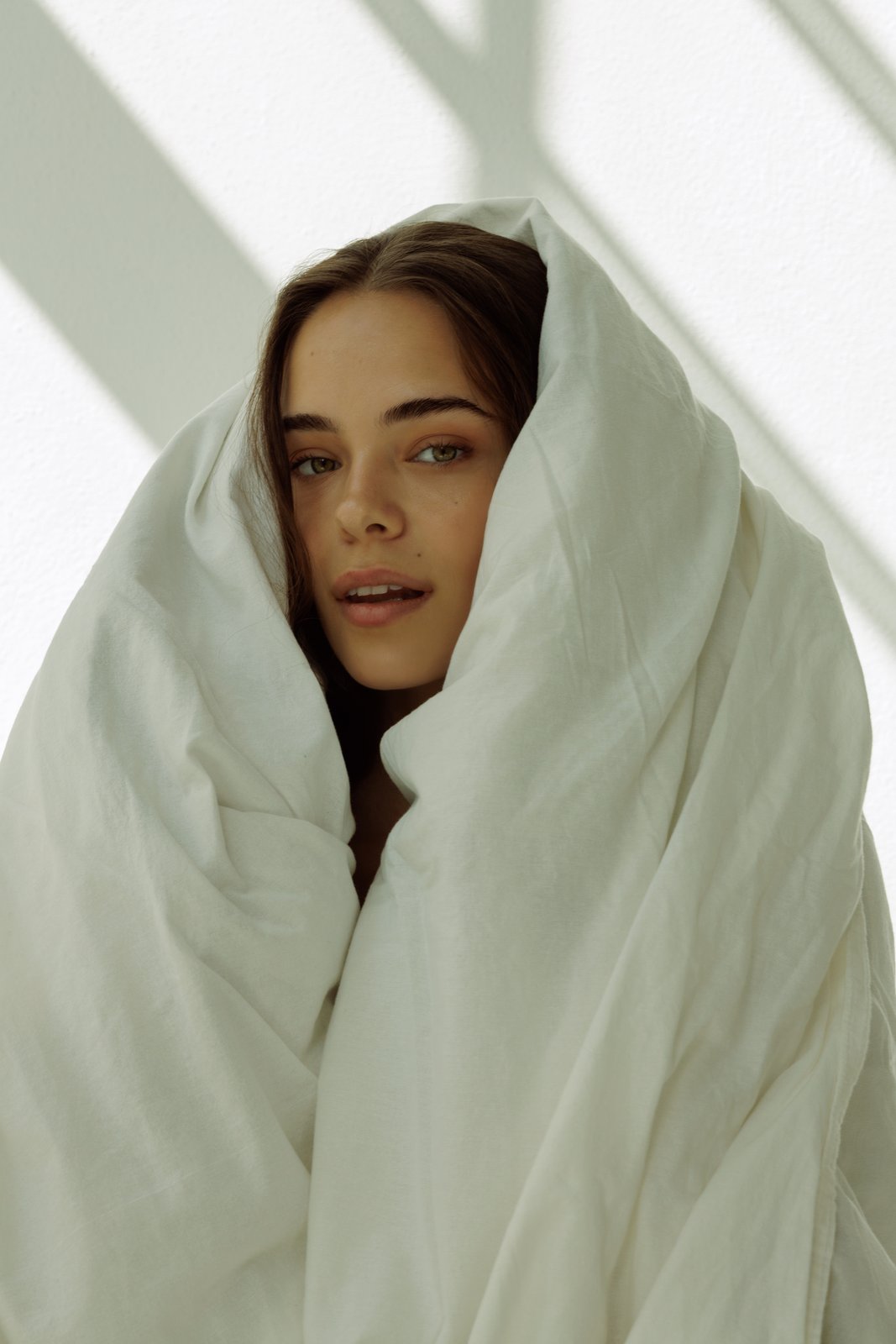 Brunette woman wrapped in a duvet